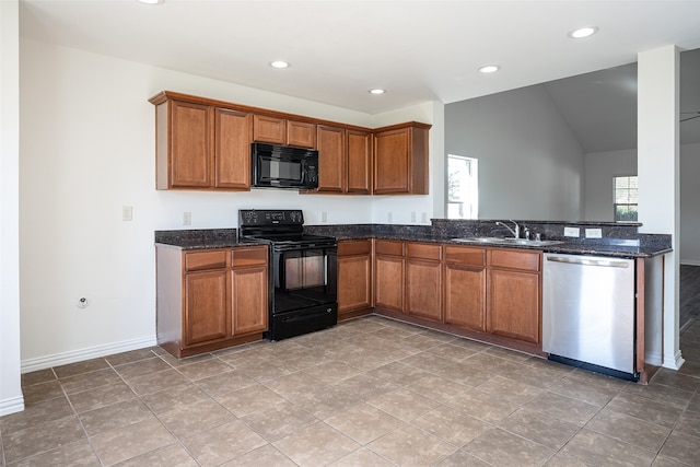 kitchen featuring sink, black appliances, dark stone countertops, and plenty of natural light