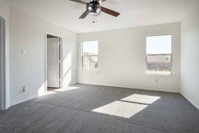 empty room featuring dark colored carpet and ceiling fan