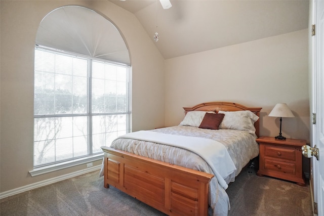 bedroom featuring ceiling fan, vaulted ceiling, and dark carpet