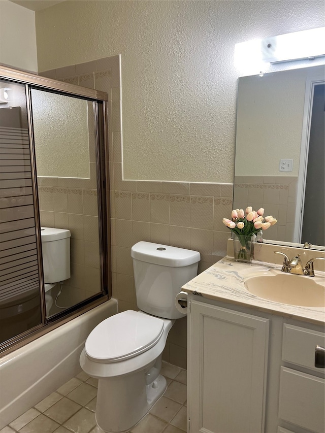 full bathroom featuring vanity, toilet, tile patterned floors, and tile walls