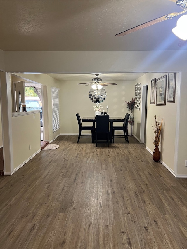 unfurnished dining area featuring dark wood-type flooring and ceiling fan