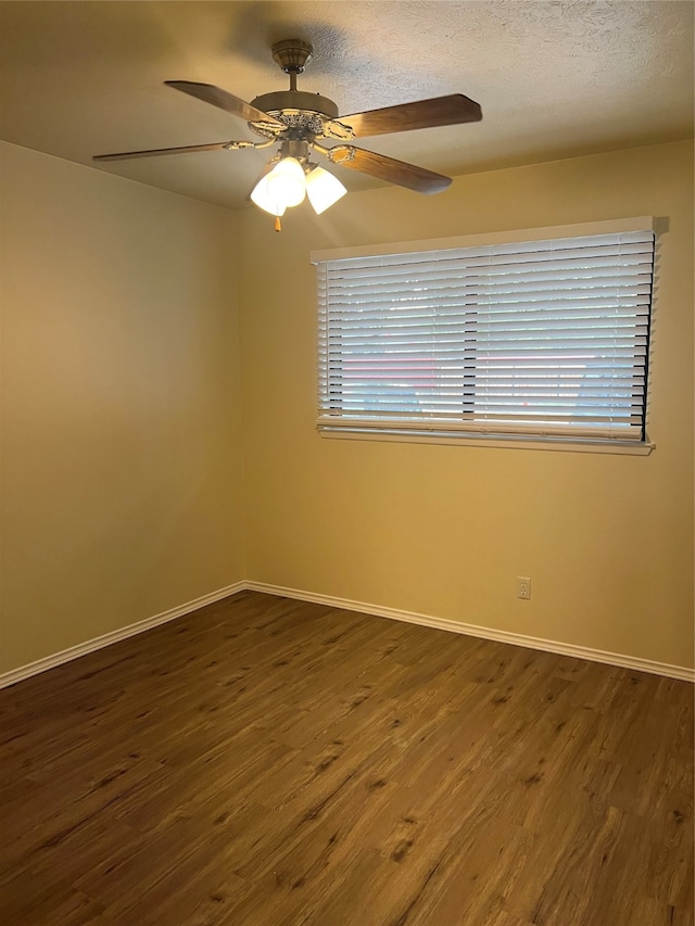 unfurnished room with a textured ceiling, dark hardwood / wood-style floors, and ceiling fan