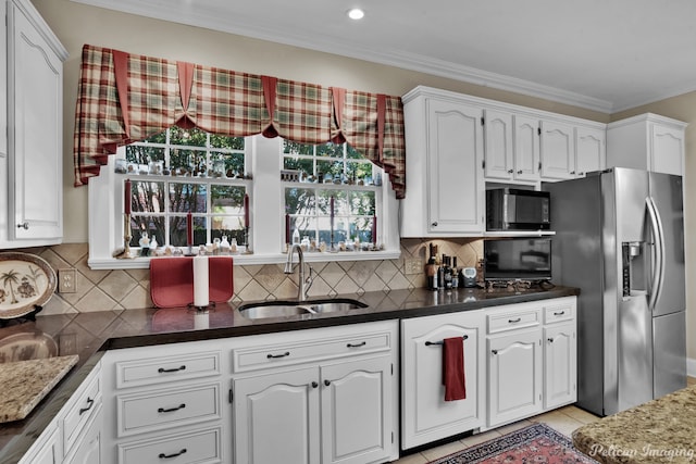 kitchen with stainless steel fridge, white cabinetry, sink, and ornamental molding