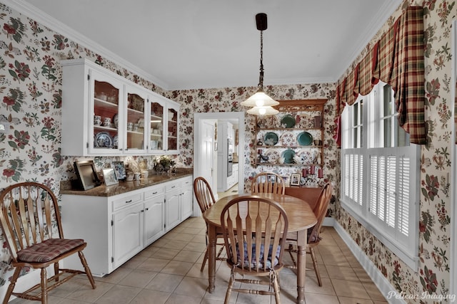 tiled dining room with a healthy amount of sunlight and ornamental molding