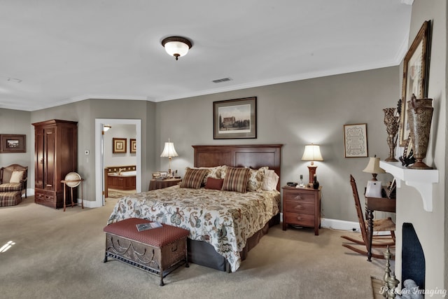 carpeted bedroom featuring ornamental molding and ensuite bathroom