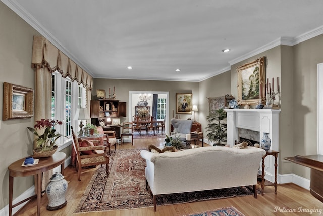 living room with light hardwood / wood-style floors, crown molding, and an inviting chandelier