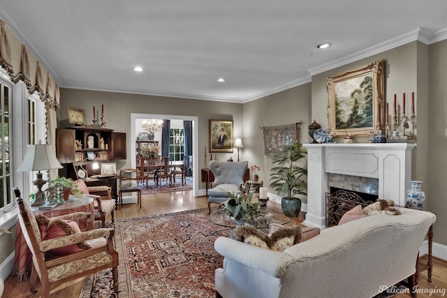 living room featuring crown molding, a fireplace, and light wood-type flooring