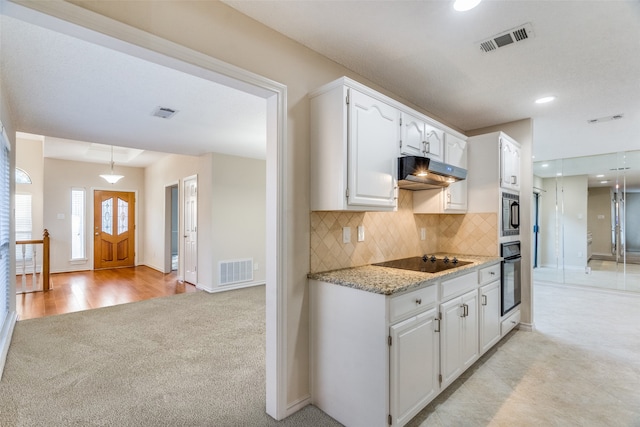 kitchen with white cabinets, appliances with stainless steel finishes, backsplash, and light carpet