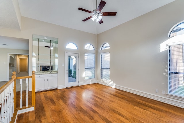 unfurnished living room featuring ceiling fan, plenty of natural light, and hardwood / wood-style flooring