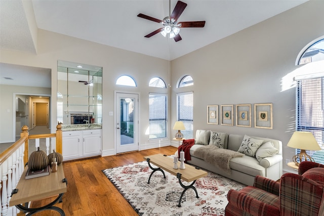 living room with ceiling fan, a high ceiling, and hardwood / wood-style flooring