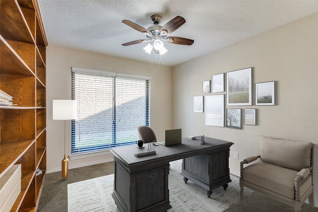 carpeted home office featuring ceiling fan and a textured ceiling