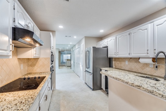 kitchen featuring sink, stainless steel appliances, light stone counters, decorative backsplash, and white cabinets