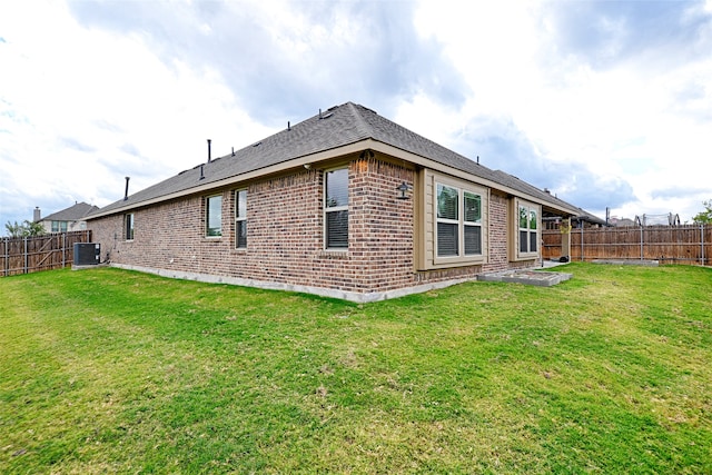 rear view of property with a lawn and central AC unit