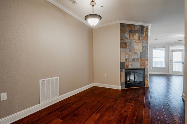 unfurnished living room featuring hardwood / wood-style flooring, ornamental molding, and a stone fireplace