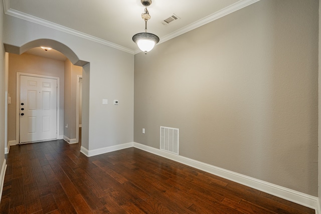 spare room featuring ornamental molding and dark hardwood / wood-style floors