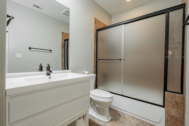 full bathroom featuring vanity, shower / bath combination with glass door, and toilet