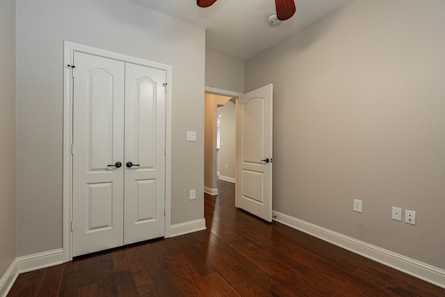 unfurnished bedroom with a closet, dark hardwood / wood-style floors, and ceiling fan