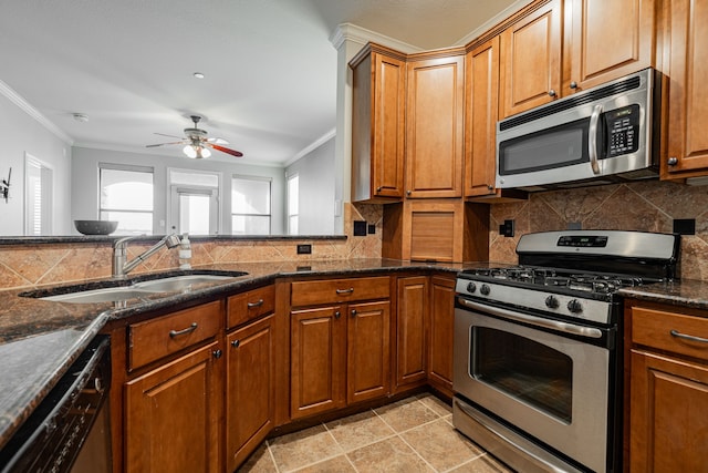 2120 Portofino Dr, Rockwall, TX 75032 - kitchen featuring appliances with stainless steel finishes, a sink, crown molding, brown cabinets, and tasteful backsplash