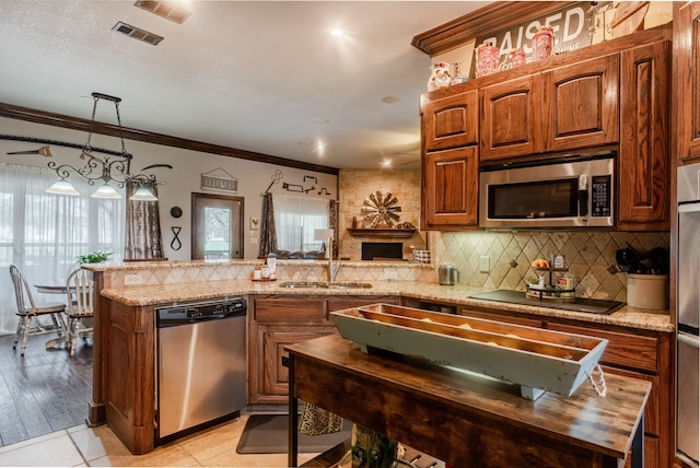 kitchen with hanging light fixtures, sink, light hardwood / wood-style floors, crown molding, and stainless steel appliances