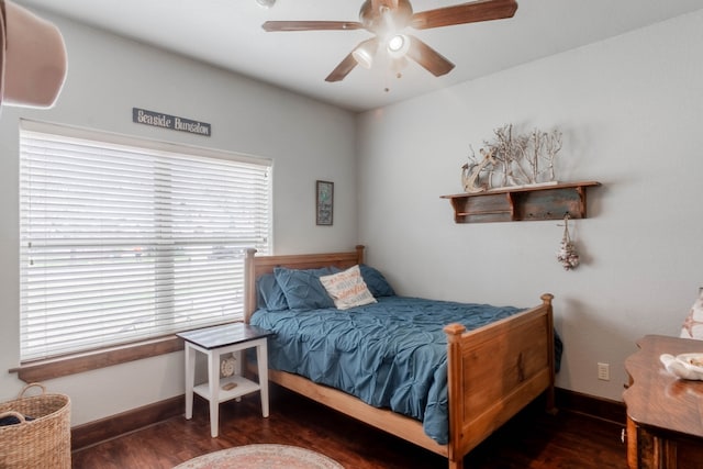 bedroom featuring multiple windows, dark wood-type flooring, and ceiling fan