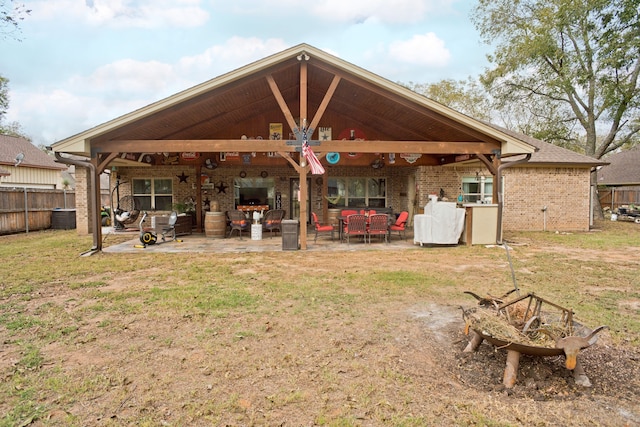 rear view of property featuring ceiling fan, a lawn, and a patio area