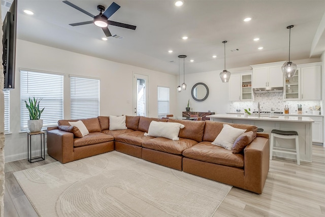 living room with ceiling fan and light hardwood / wood-style flooring