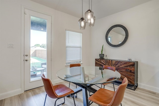 dining space featuring an inviting chandelier and light wood-type flooring