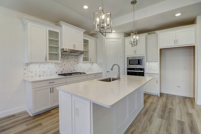 kitchen with sink, appliances with stainless steel finishes, decorative light fixtures, and white cabinetry