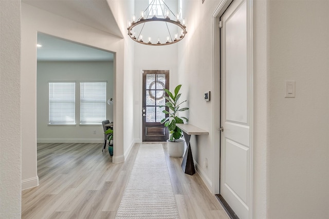 foyer entrance with a notable chandelier and light hardwood / wood-style floors