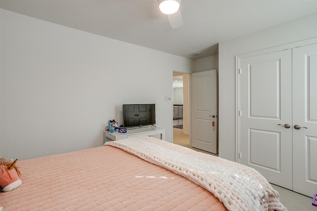 bedroom featuring a closet, ceiling fan, and light carpet