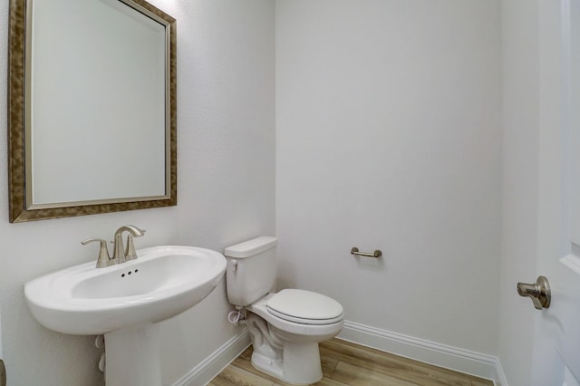 bathroom with toilet and hardwood / wood-style floors