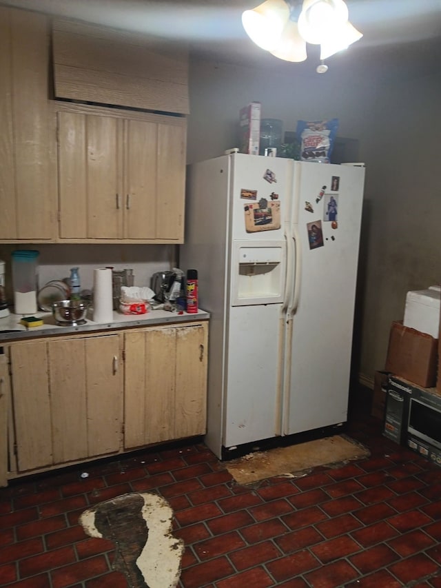 kitchen with light brown cabinetry and white refrigerator with ice dispenser