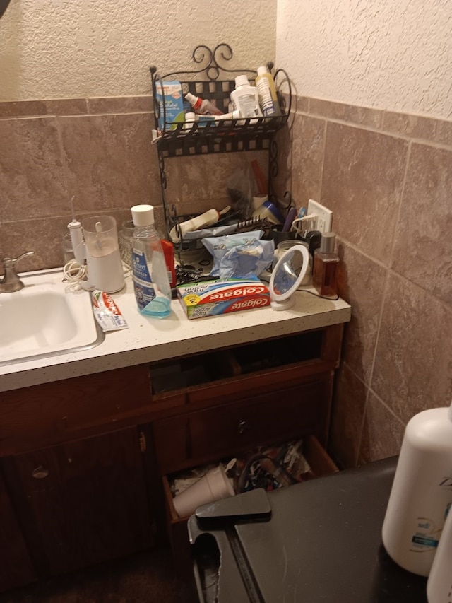 bathroom with vanity and tile walls