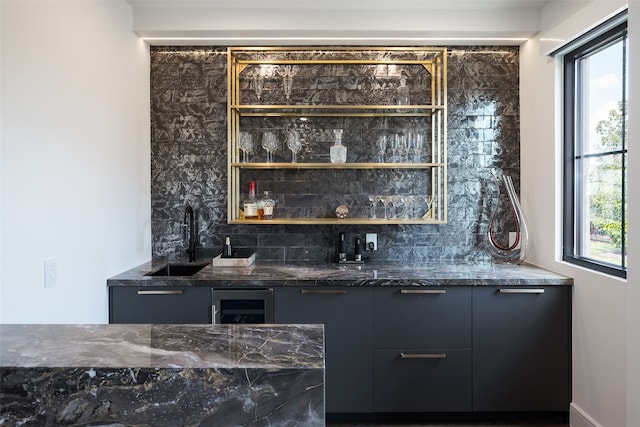 bar with sink, a healthy amount of sunlight, and tasteful backsplash