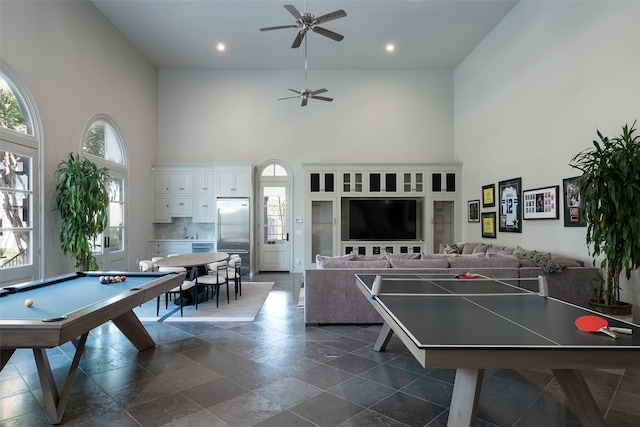 game room with a towering ceiling, sink, pool table, and ceiling fan