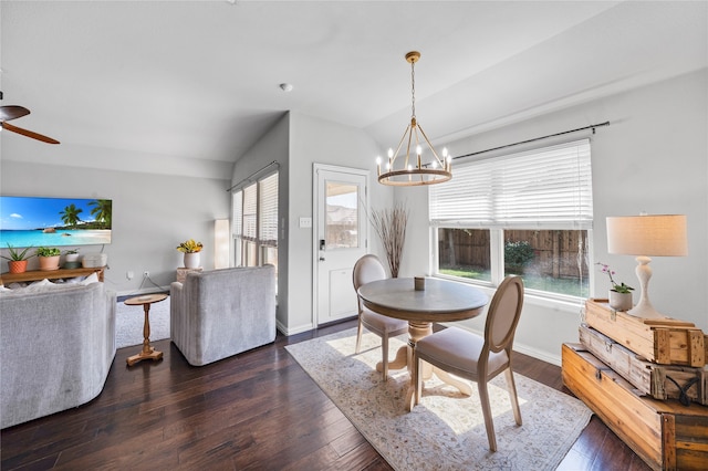 dining room featuring ceiling fan with notable chandelier, dark hardwood / wood-style flooring, and vaulted ceiling