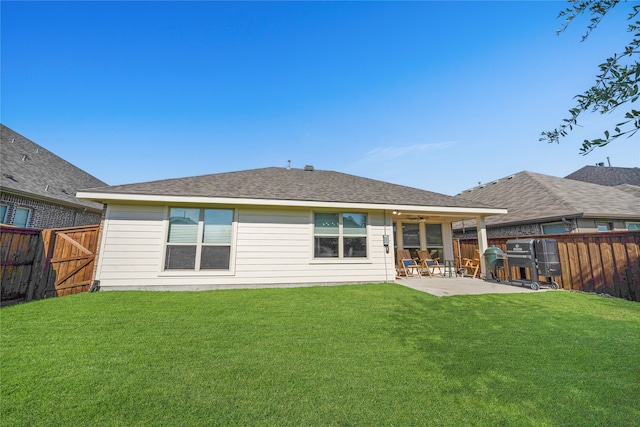 back of house featuring a lawn, ceiling fan, and a patio