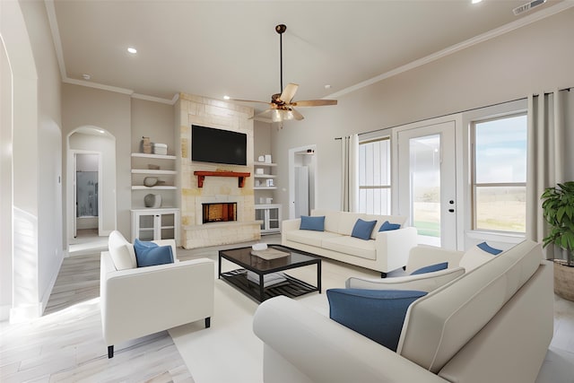 living room with a fireplace, ceiling fan, light hardwood / wood-style floors, and crown molding