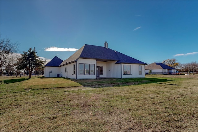 rear view of house with a yard and cooling unit