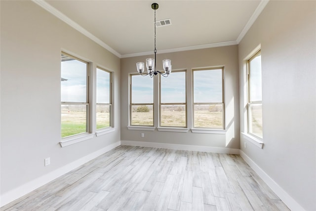 unfurnished dining area with baseboards, visible vents, crown molding, light wood-type flooring, and a chandelier