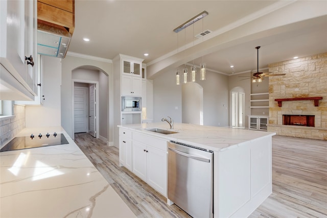 kitchen featuring arched walkways, stainless steel appliances, a sink, visible vents, and ornamental molding