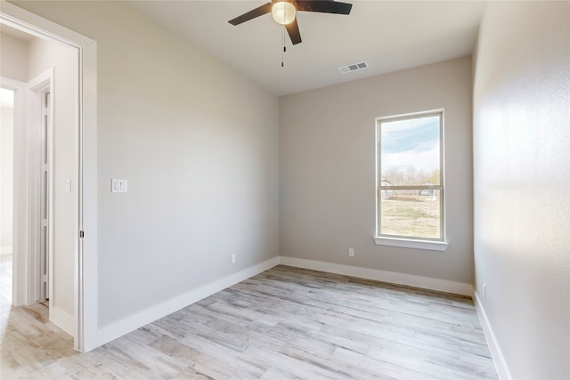 spare room featuring baseboards, a ceiling fan, visible vents, and light wood-style floors