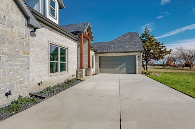 view of home's exterior with brick siding, a shingled roof, a lawn, an attached garage, and driveway