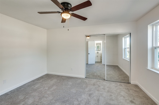 unfurnished bedroom with light carpet, a closet, and ceiling fan