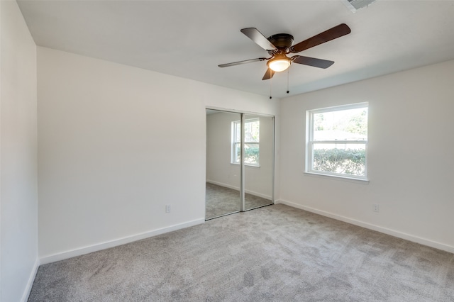 unfurnished bedroom with light carpet, a closet, and ceiling fan