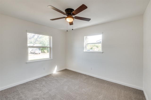 spare room featuring light colored carpet and ceiling fan