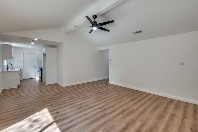 unfurnished living room with sink, ceiling fan, lofted ceiling with beams, and light hardwood / wood-style flooring