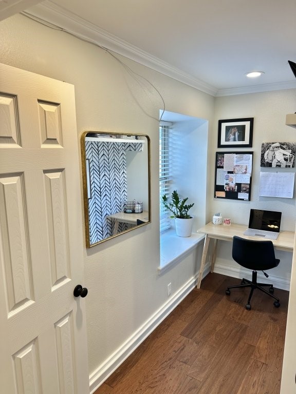 office area featuring crown molding, built in desk, and dark hardwood / wood-style flooring