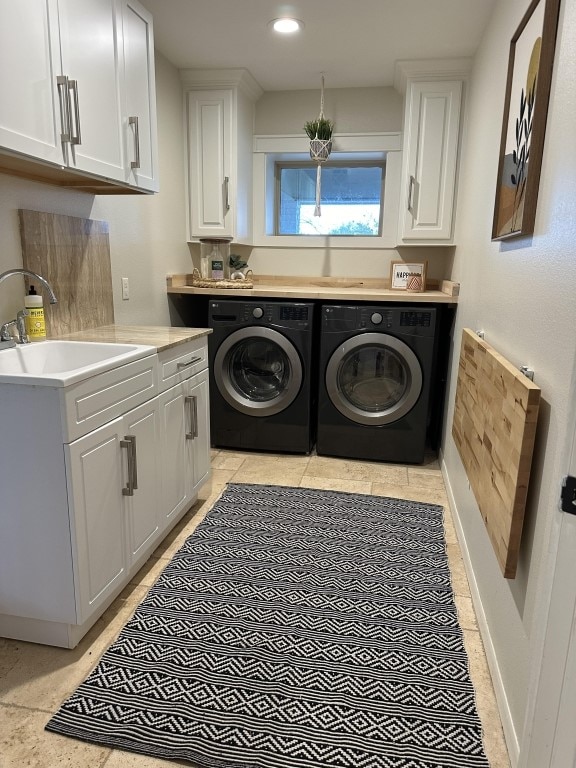 washroom featuring sink, separate washer and dryer, and cabinets