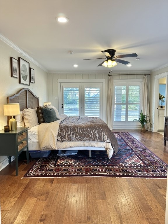 bedroom with hardwood / wood-style floors, multiple windows, and ceiling fan